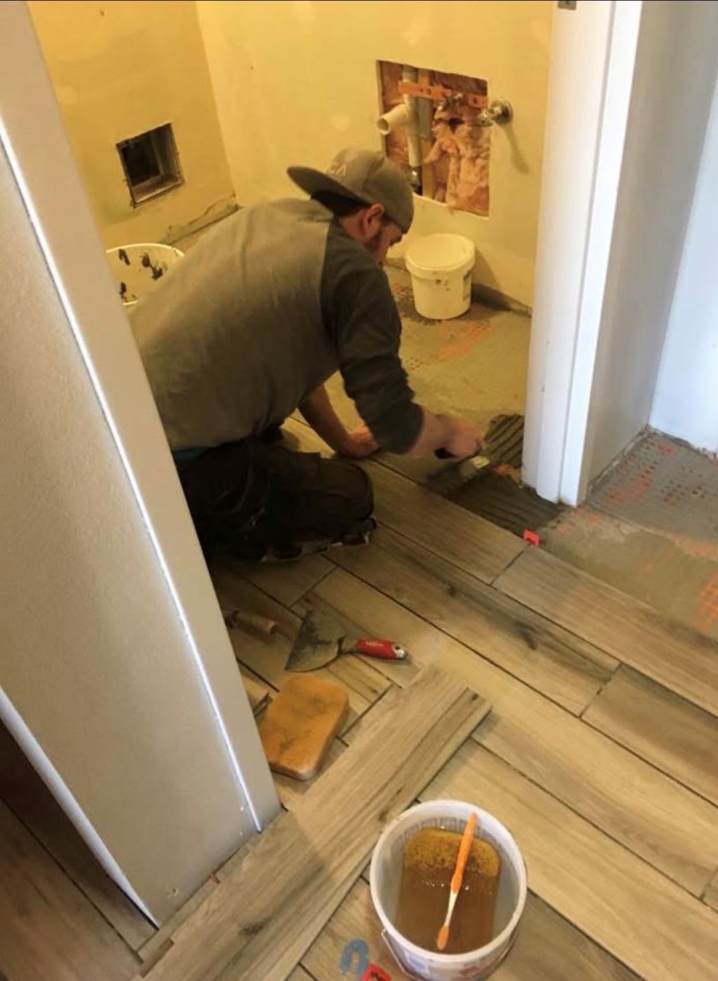 Aaron laying new plank flooring